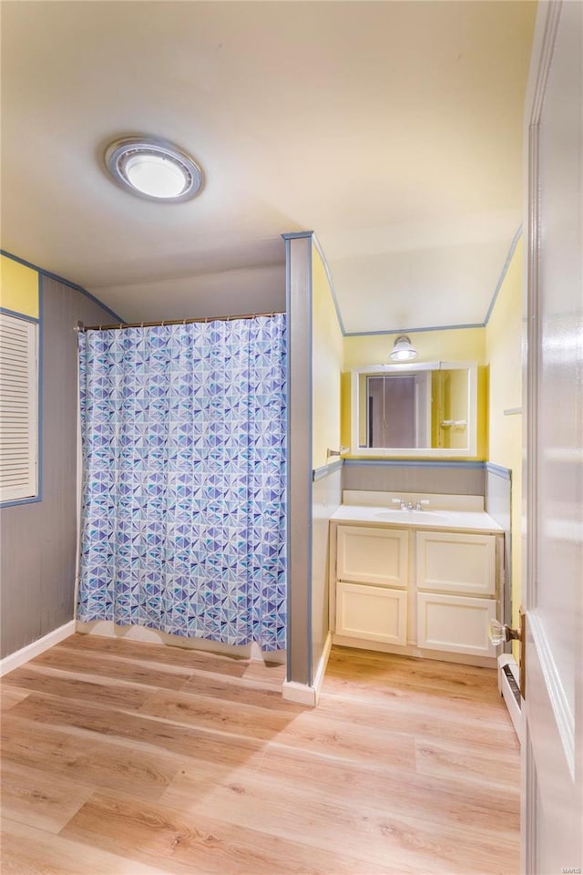 bathroom featuring hardwood / wood-style flooring, vanity, and lofted ceiling