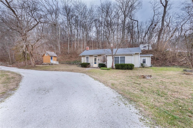 view of front facade featuring a shed and a front lawn