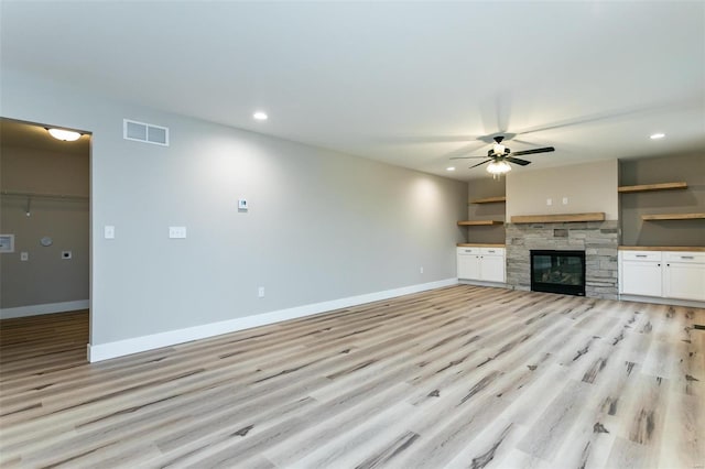 unfurnished living room featuring a fireplace, light hardwood / wood-style floors, and ceiling fan