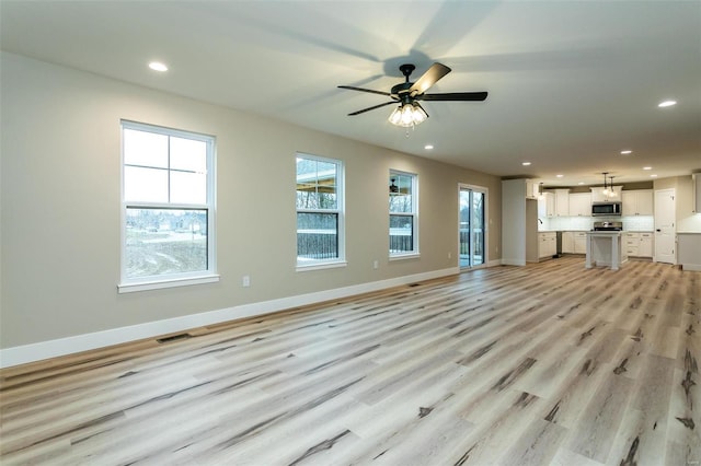 unfurnished living room featuring light hardwood / wood-style floors and ceiling fan