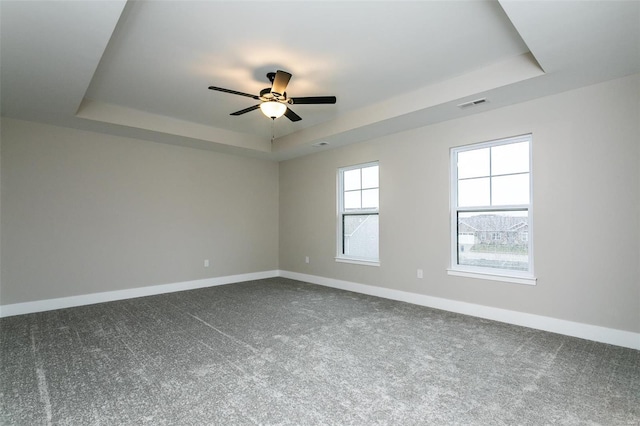 carpeted empty room featuring ceiling fan and a tray ceiling