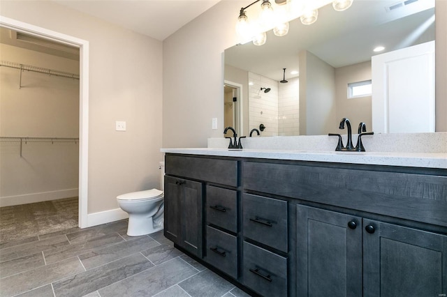 bathroom featuring vanity, toilet, and a tile shower