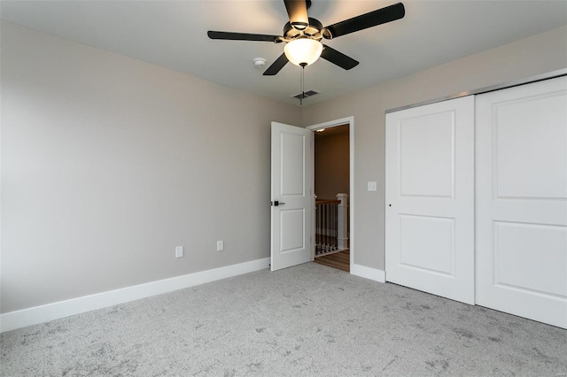 unfurnished bedroom with light colored carpet, a closet, and ceiling fan