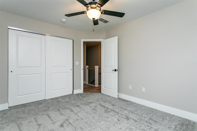 unfurnished bedroom with ceiling fan, carpet floors, and a closet