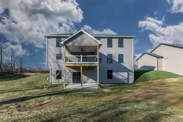 back of property featuring a yard, a balcony, a patio, and ceiling fan