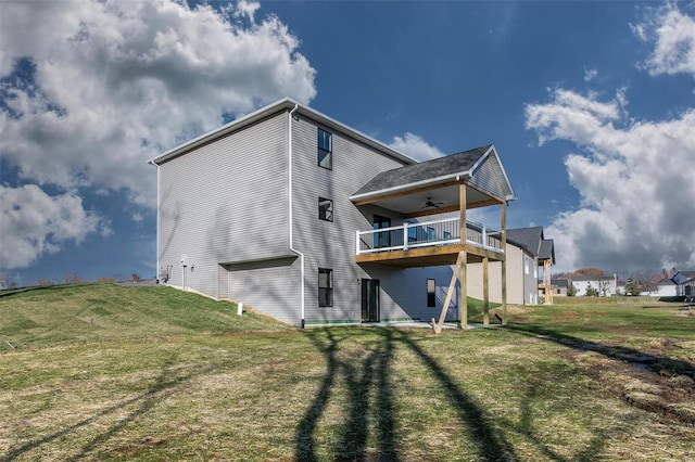 rear view of house with a lawn and ceiling fan