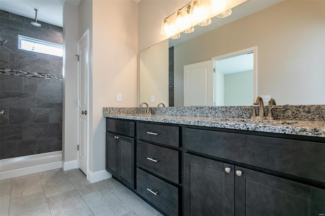 bathroom featuring tiled shower and vanity