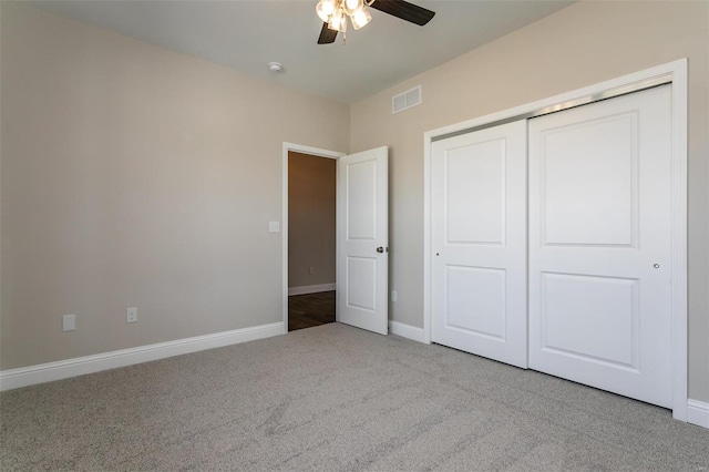 unfurnished bedroom featuring ceiling fan, light colored carpet, and a closet