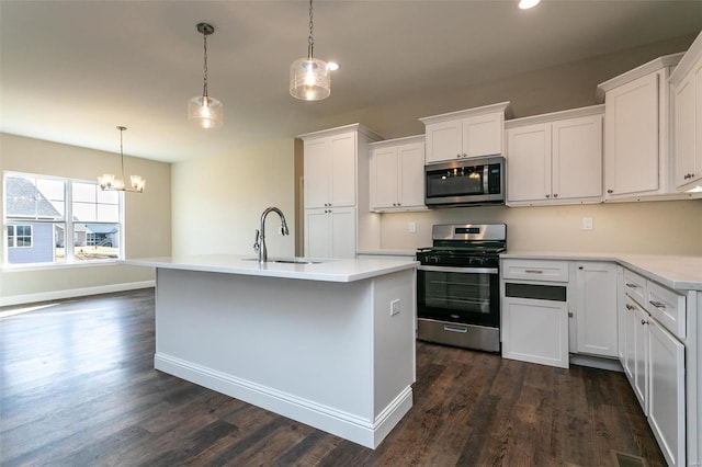 kitchen featuring white cabinetry, appliances with stainless steel finishes, decorative light fixtures, and sink