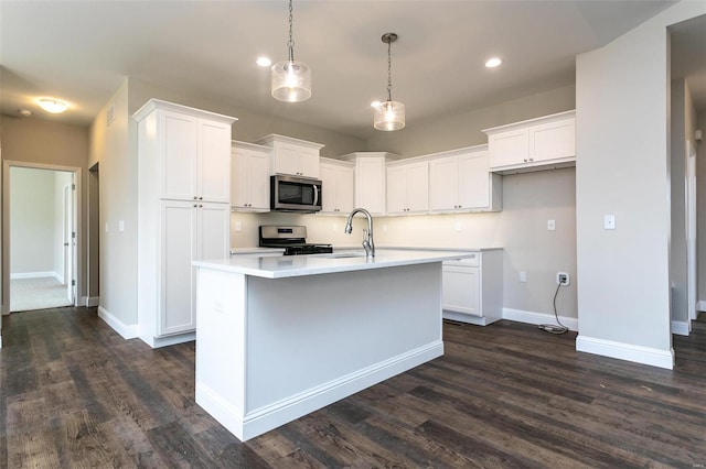 kitchen featuring sink, a kitchen island with sink, hanging light fixtures, stainless steel appliances, and white cabinets