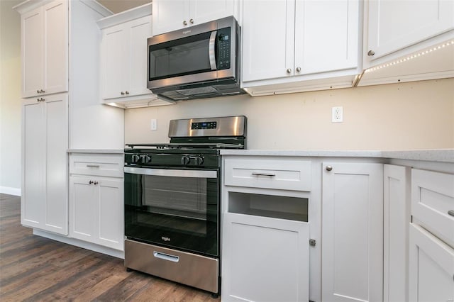 kitchen with white cabinetry, stainless steel appliances, and dark wood-type flooring