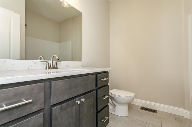 bathroom featuring tile patterned floors, toilet, vanity, and a shower