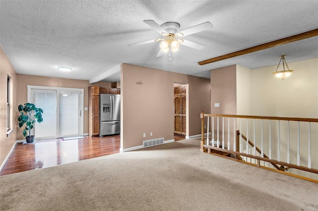 unfurnished room with ceiling fan, a textured ceiling, and light hardwood / wood-style flooring