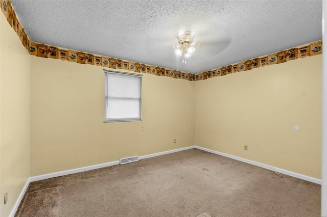 spare room featuring carpet, a textured ceiling, and ceiling fan