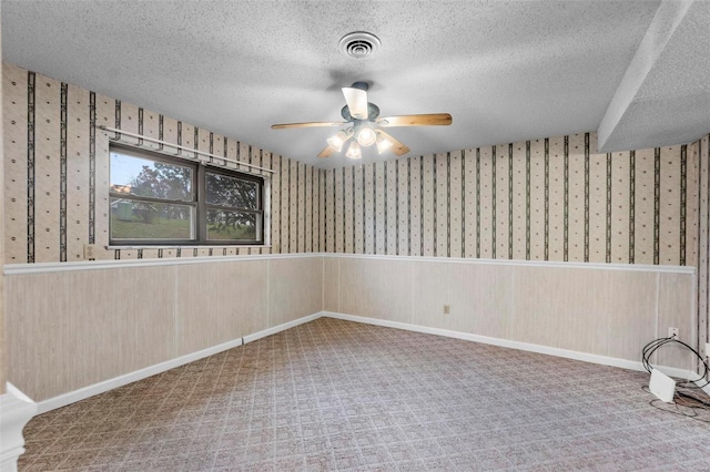 empty room featuring ceiling fan, carpet floors, and a textured ceiling