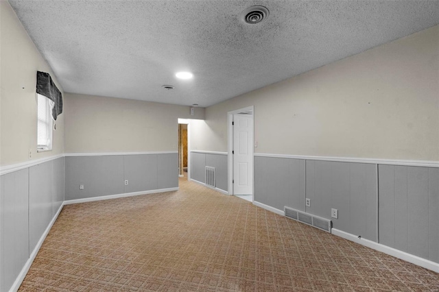 carpeted empty room featuring a textured ceiling