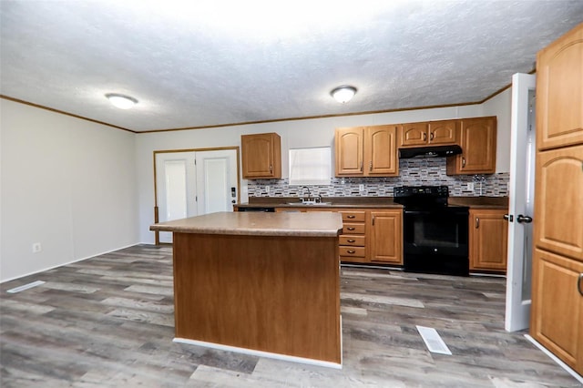 kitchen with electric range, dark hardwood / wood-style flooring, a kitchen island, and sink