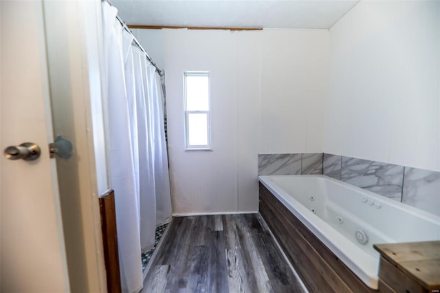 bathroom with wood-type flooring and shower with separate bathtub