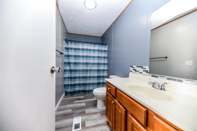 bathroom with walk in shower, vanity, a textured ceiling, wood-type flooring, and toilet