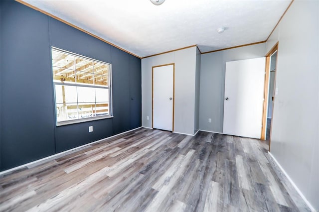 unfurnished bedroom with wood-type flooring and ornamental molding