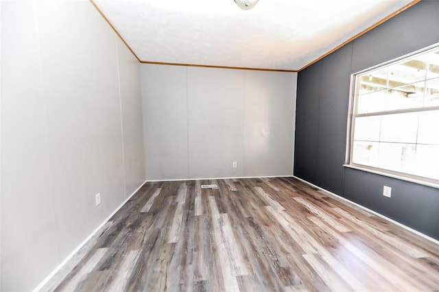 unfurnished room with ornamental molding and hardwood / wood-style flooring