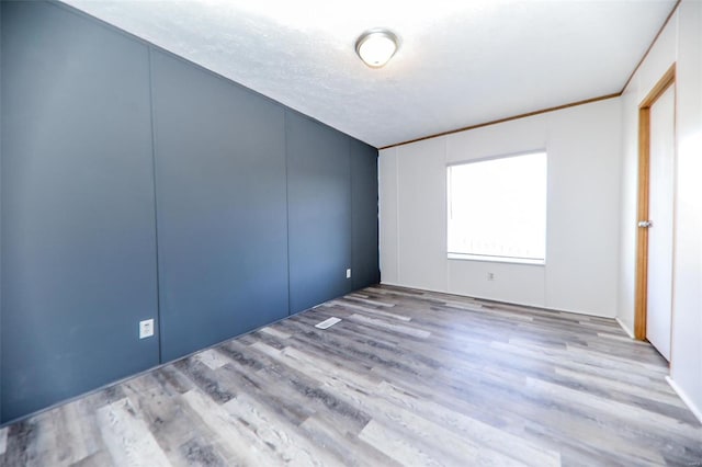 empty room featuring light hardwood / wood-style floors and a textured ceiling