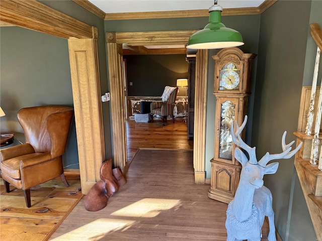 living area with hardwood / wood-style flooring and ornamental molding