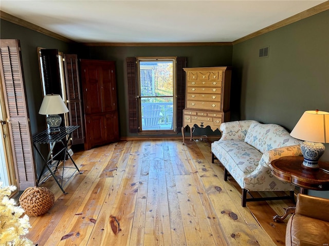 sitting room featuring ornamental molding and light wood-type flooring