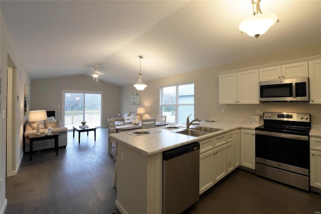 kitchen featuring kitchen peninsula, appliances with stainless steel finishes, vaulted ceiling, and sink