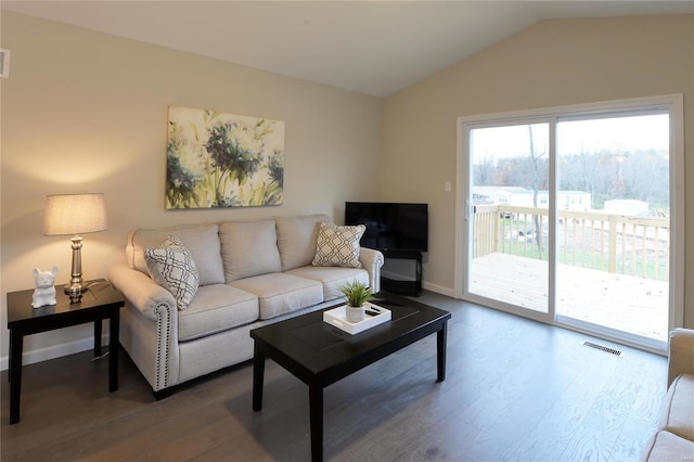 living room featuring lofted ceiling and hardwood / wood-style flooring