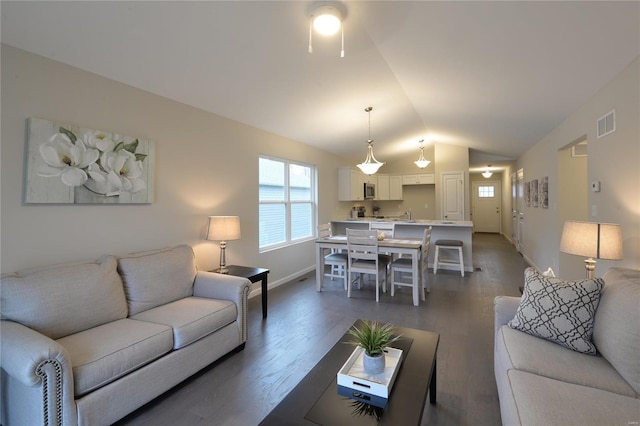 living room with dark hardwood / wood-style floors and vaulted ceiling