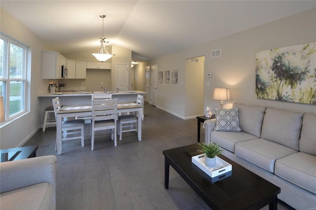 living room with dark hardwood / wood-style floors, a wealth of natural light, lofted ceiling, and sink