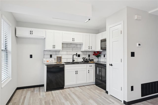 kitchen featuring sink, white cabinetry, tasteful backsplash, and black appliances