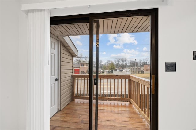 doorway to outside with hardwood / wood-style floors and wood walls