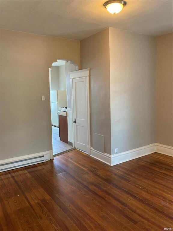 spare room featuring hardwood / wood-style floors and a baseboard heating unit