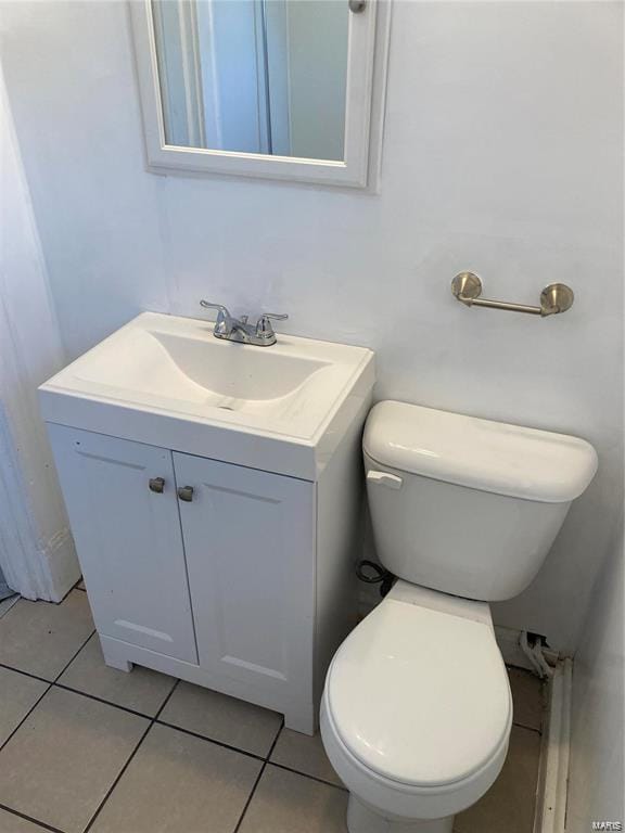 bathroom with tile patterned flooring, vanity, and toilet