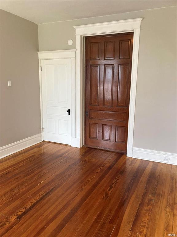 unfurnished bedroom with dark wood-type flooring