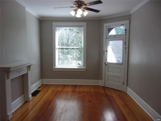 doorway with ceiling fan, dark hardwood / wood-style flooring, crown molding, and a wealth of natural light