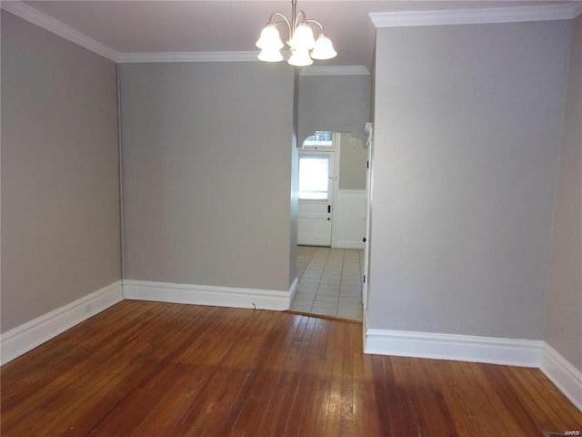 unfurnished room with a chandelier, hardwood / wood-style flooring, and crown molding