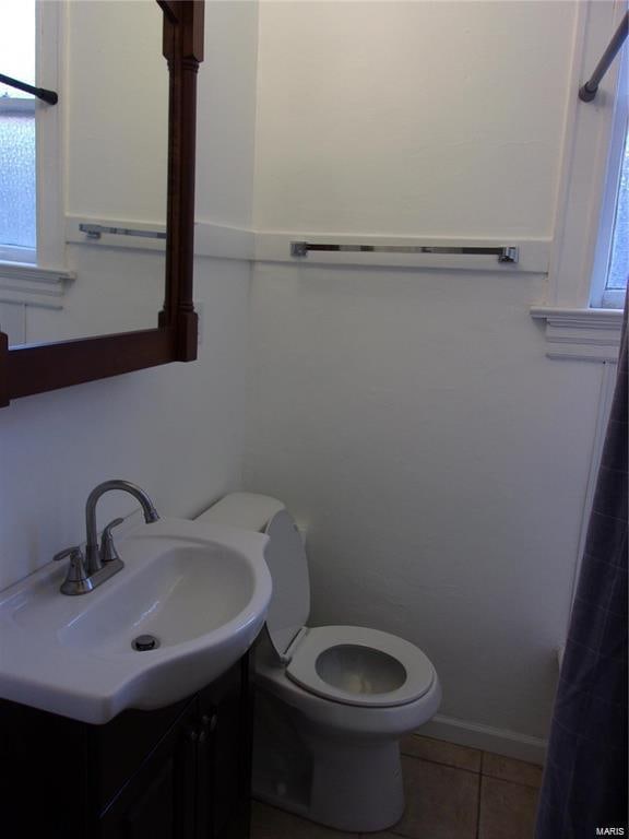 bathroom with tile patterned flooring, vanity, and toilet