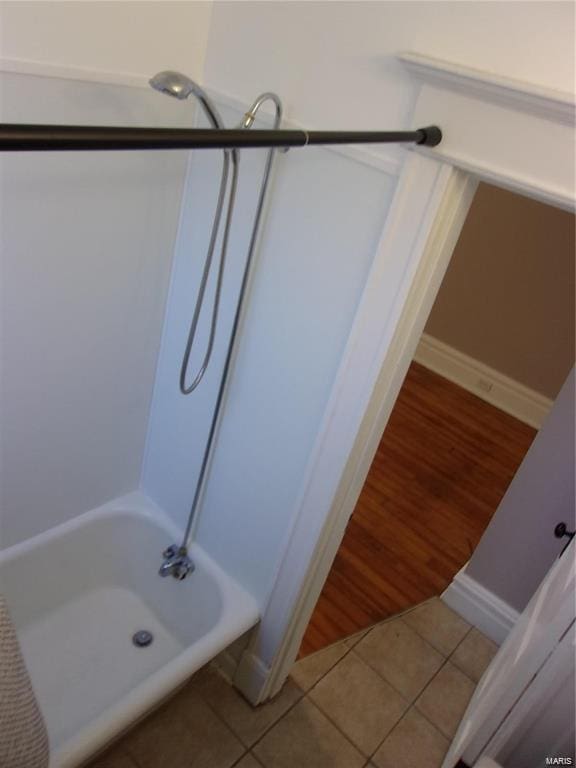 bathroom featuring tile patterned flooring and  shower combination