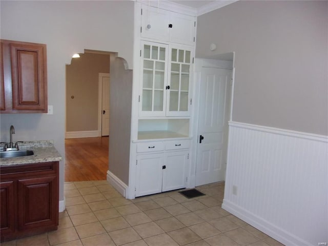 interior space featuring sink, light tile patterned floors, and ornamental molding