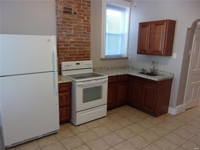 kitchen with light stone countertops, sink, light tile patterned floors, and white appliances