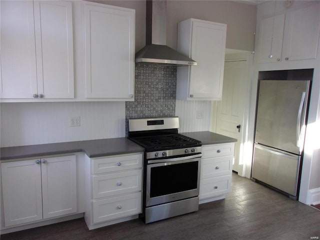 kitchen with wall chimney exhaust hood, dark hardwood / wood-style floors, decorative backsplash, white cabinetry, and stainless steel appliances