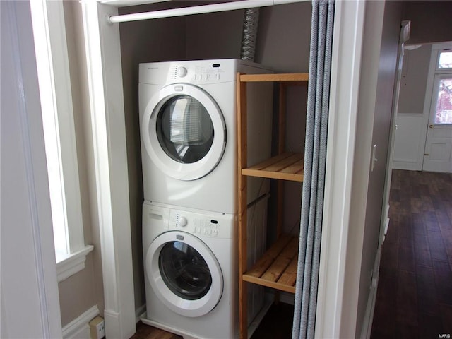 washroom featuring dark hardwood / wood-style floors and stacked washer and clothes dryer