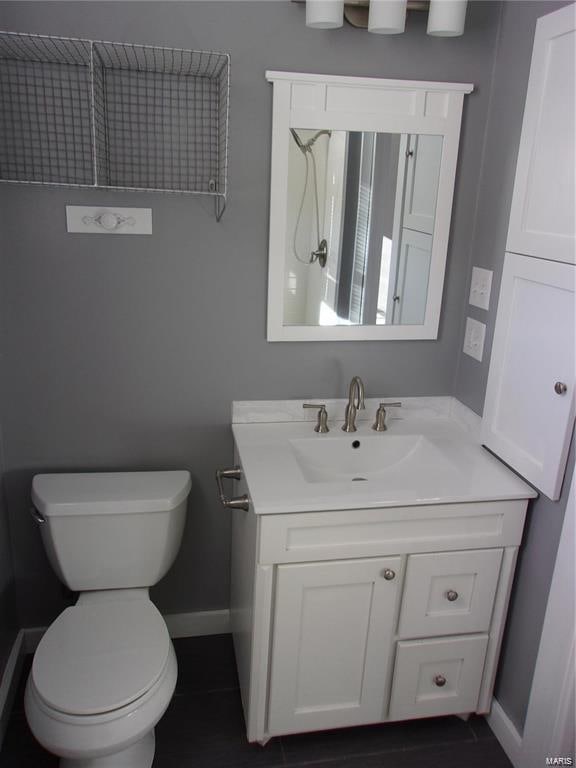 bathroom featuring tile patterned floors, vanity, and toilet