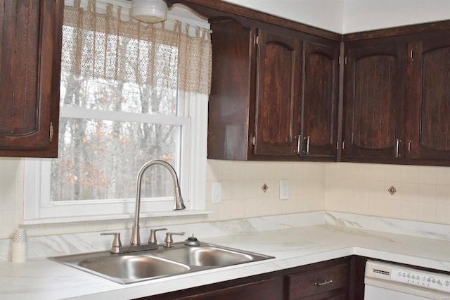 kitchen with dishwasher, dark brown cabinetry, and sink