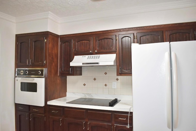 kitchen featuring tasteful backsplash, ornamental molding, a textured ceiling, white appliances, and dark brown cabinetry