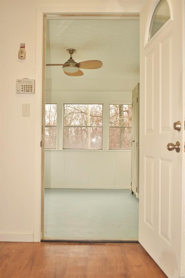 unfurnished sunroom with ceiling fan