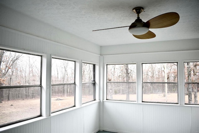 unfurnished sunroom featuring ceiling fan